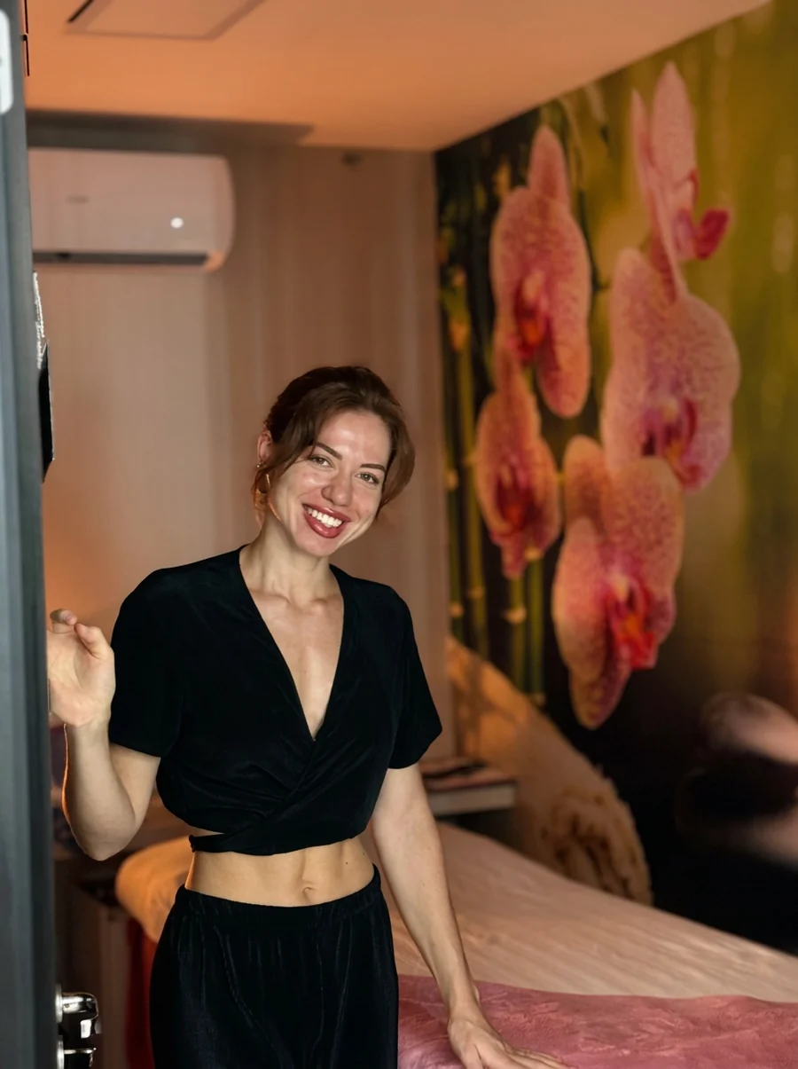 Júlia Tavares, esteticista, sorrindo na recepção da clínica
